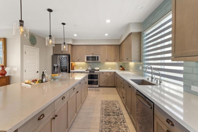 6132 Colt Pl Unit 101, Carlsbad, CA 92009 - kitchen with appliances with stainless steel finishes, decorative backsplash, a large island, hanging light fixtures, and recessed lighting