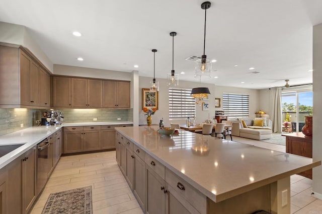 6132 Colt Pl Unit 101, Carlsbad, CA 92009 - kitchen with a large island, backsplash, light countertops, recessed lighting, and pendant lighting