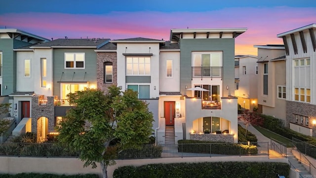 6132 Colt Pl Unit 101, Carlsbad, CA 92009 - view of front facade featuring a balcony, a fenced front yard, and stucco siding