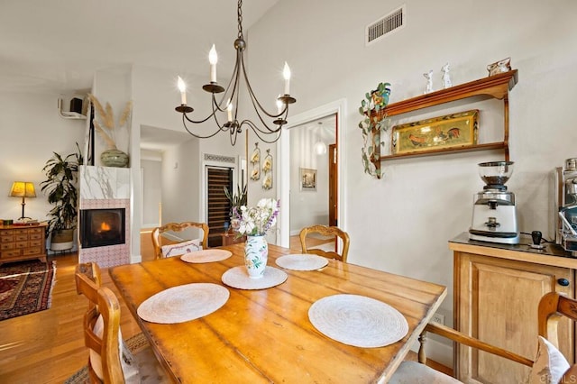 1850 Willowhaven Rd, Encinitas, CA 92024 - dining space with wood finished floors, a chandelier, a tile fireplace, and wine cooler