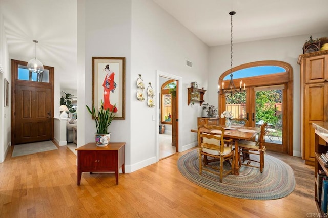 1850 Willowhaven Rd, Encinitas, CA 92024 - dining area with a chandelier, a towering ceiling, and light wood-style floors