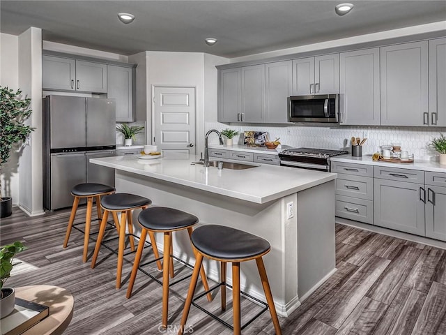 35203 Lopez Ln, Beaumont, CA 92223 - kitchen with appliances with stainless steel finishes, a sink, gray cabinets, a kitchen breakfast bar, and recessed lighting