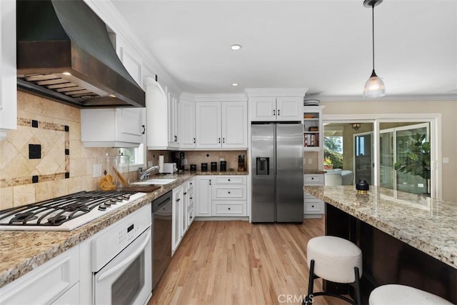 1981 San Remo, Laguna Beach, CA 92651 - kitchen featuring appliances with stainless steel finishes, wall chimney exhaust hood, white cabinetry, light stone countertops, and recessed lighting
