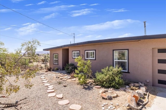 61961 Aster Pl, Joshua Tree, CA 92252 - back of house featuring stucco siding and fence