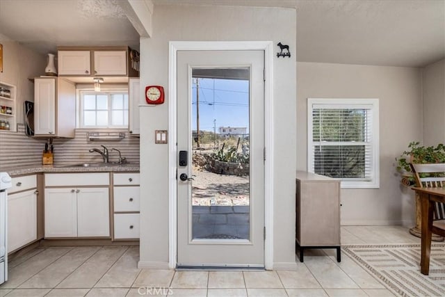 61961 Aster Pl, Joshua Tree, CA 92252 - kitchen with light tile patterned floors, tasteful backsplash, and white cabinetry