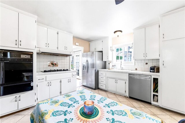 17331 Newland St, Huntington Beach, CA 92647 - kitchen featuring black appliances, a warming drawer, a sink, tile counters, and decorative backsplash