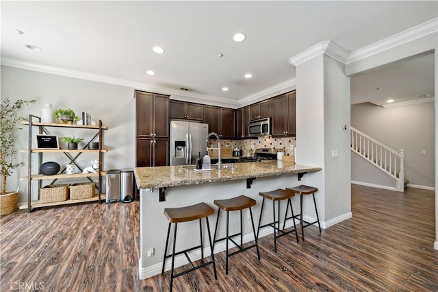 27423 Larabee Ct Unit 3, Murrieta, CA 92562 - kitchen featuring appliances with stainless steel finishes, dark wood-style flooring, dark brown cabinets, backsplash, and a peninsula