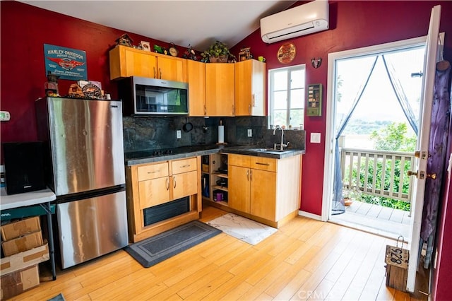 22460 Venido Rd, Woodland Hills, CA 91364 - kitchen featuring stainless steel appliances, a wall mounted air conditioner, a sink, tasteful backsplash, and light wood-style flooring