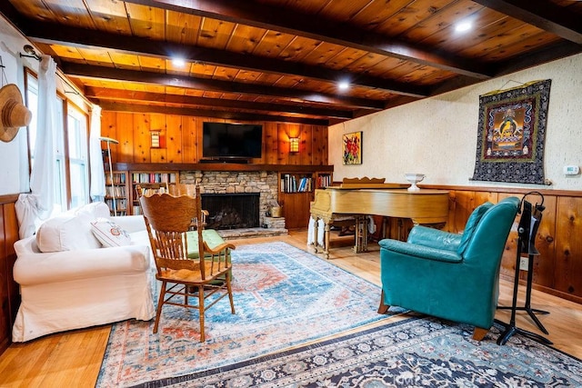 22460 Venido Rd, Woodland Hills, CA 91364 - living area with wood ceiling with exposed beams, wooden walls, wood finished floors, a stone fireplace, and a wainscoted wall
