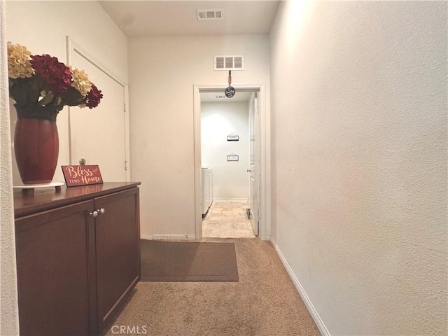 18016 Ribwort Rd, San Bernardino, CA 92407 - corridor with light colored carpet, washer and clothes dryer, and baseboards