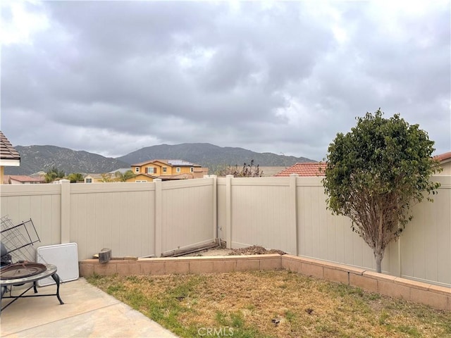 18016 Ribwort Rd, San Bernardino, CA 92407 - fenced backyard with a mountain view, a patio area, and a fire pit