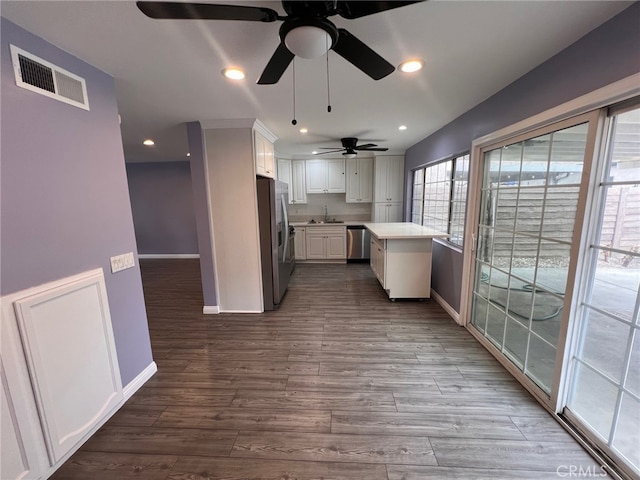 1007 Harrington Way, West Covina, CA 91792 - kitchen with stainless steel appliances, baseboards, white cabinetry, ceiling fan, and dark wood-type flooring