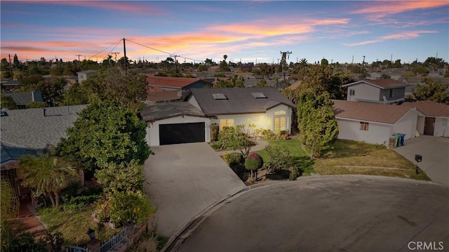 ranch-style house with concrete driveway, a residential view, a lawn, and an attached garage