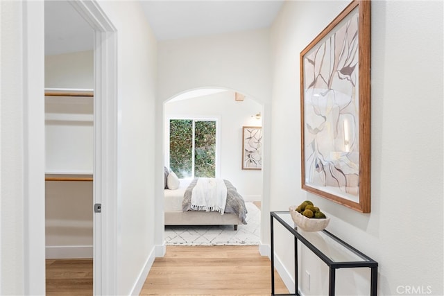 hallway featuring wood finished floors and arched walkways
