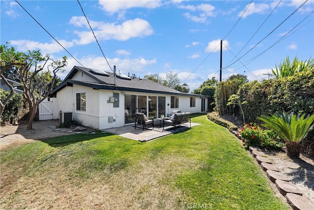 back of property with an outdoor hangout area, roof mounted solar panels, stucco siding, a patio, and a gate