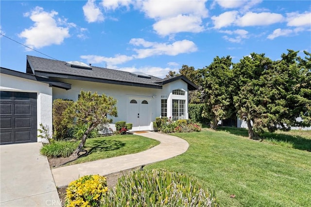 ranch-style house with a front yard, stucco siding, a garage, and driveway