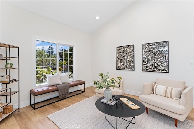 living room featuring wood finished floors, baseboards, high vaulted ceiling, and recessed lighting