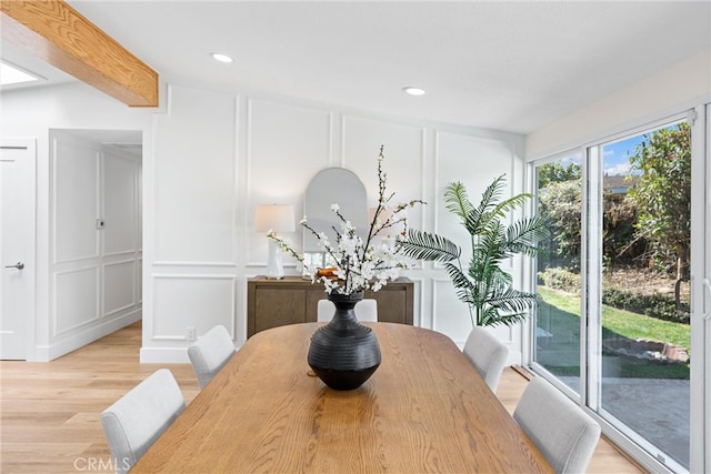 dining space with a decorative wall, light wood-type flooring, and recessed lighting