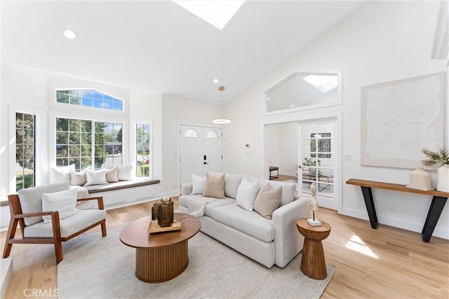 living room featuring high vaulted ceiling, healthy amount of natural light, light wood-style floors, and recessed lighting