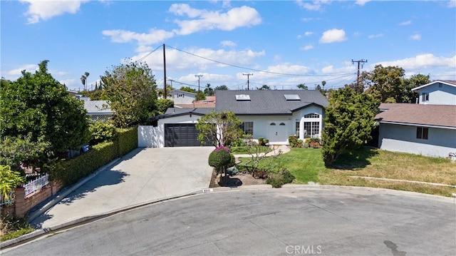 view of front facade featuring driveway, a front yard, and an attached garage