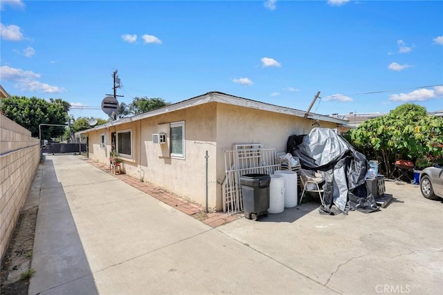 view of side of property featuring stucco siding and fence