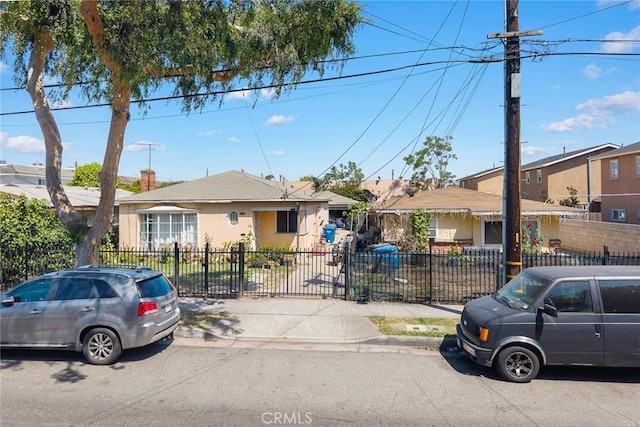 view of front of home with a fenced front yard, a residential view, stucco siding, and a chimney