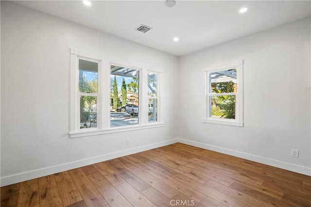 spare room featuring baseboards, wood-type flooring, and recessed lighting