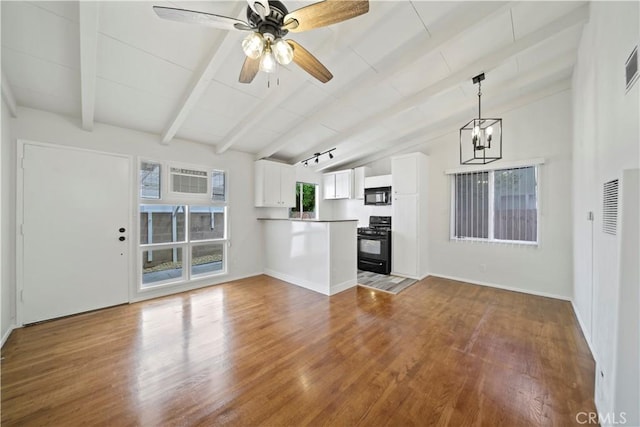 unfurnished living room featuring wood finished floors, a ceiling fan, a chandelier, and baseboards