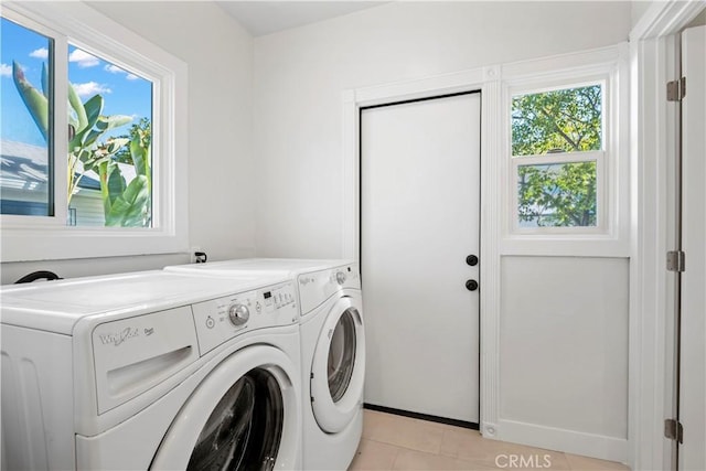 laundry room with independent washer and dryer, light tile patterned floors, and baseboards