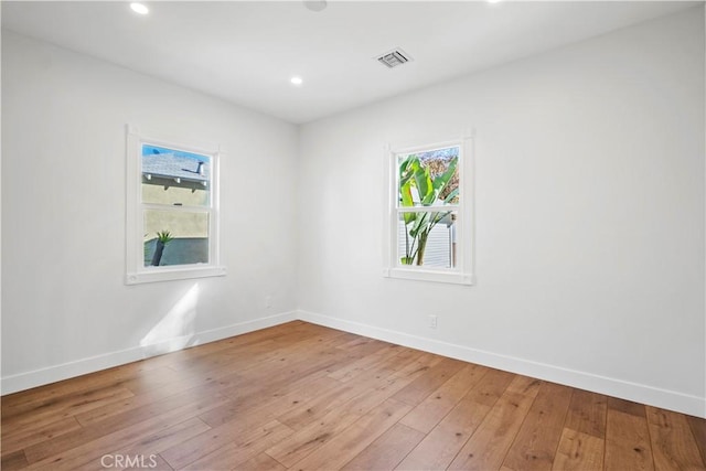 spare room with baseboards, hardwood / wood-style flooring, and recessed lighting