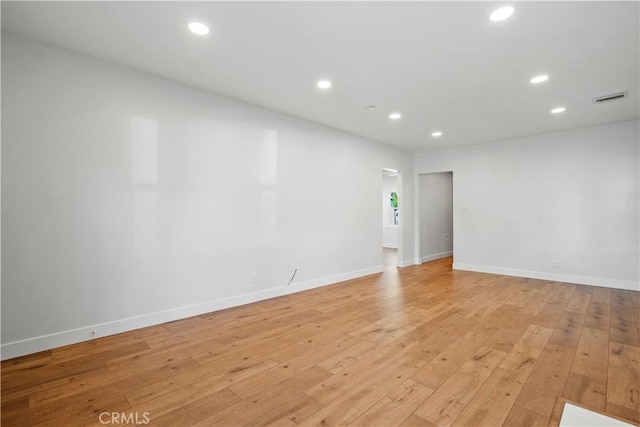 empty room with light wood-style floors, recessed lighting, and baseboards