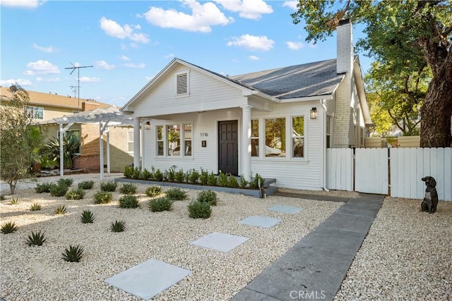 bungalow-style house featuring a pergola, fence, a chimney, and a shingled roof
