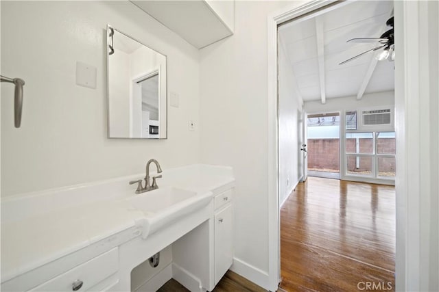 bathroom featuring beamed ceiling, wood finished floors, a ceiling fan, baseboards, and an AC wall unit