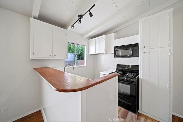 kitchen with black appliances, light wood-style flooring, white cabinets, and a peninsula