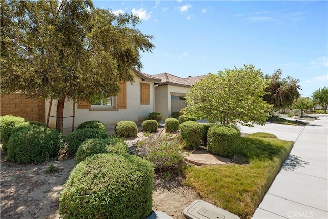 30156 Bristol Gate Ln, Menifee, CA 92584 - view of property hidden behind natural elements featuring an attached garage, stucco siding, and a tile roof
