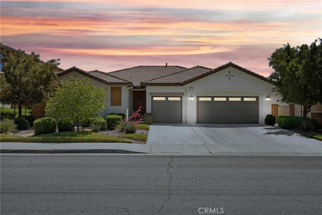 30156 Bristol Gate Ln, Menifee, CA 92584 - mediterranean / spanish-style home featuring an attached garage, driveway, stucco siding, and a tiled roof