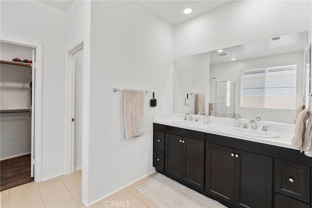 30156 Bristol Gate Ln, Menifee, CA 92584 - full bath featuring double vanity, a walk in closet, a shower stall, tile patterned flooring, and baseboards