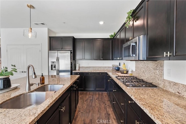 30156 Bristol Gate Ln, Menifee, CA 92584 - kitchen with stainless steel appliances, a sink, dark wood-style flooring, light stone countertops, and pendant lighting