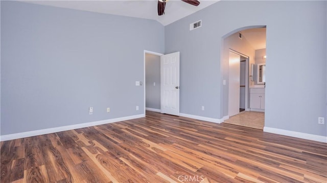 31695 Corte Avalos, Temecula, CA 92592 - unfurnished bedroom featuring arched walkways, wood finished floors, connected bathroom, ceiling fan, and high vaulted ceiling