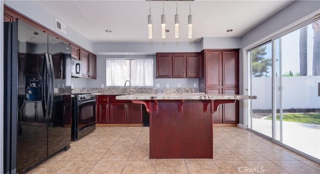 31695 Corte Avalos, Temecula, CA 92592 - kitchen featuring black appliances, plenty of natural light, dark brown cabinets, a kitchen bar, and recessed lighting