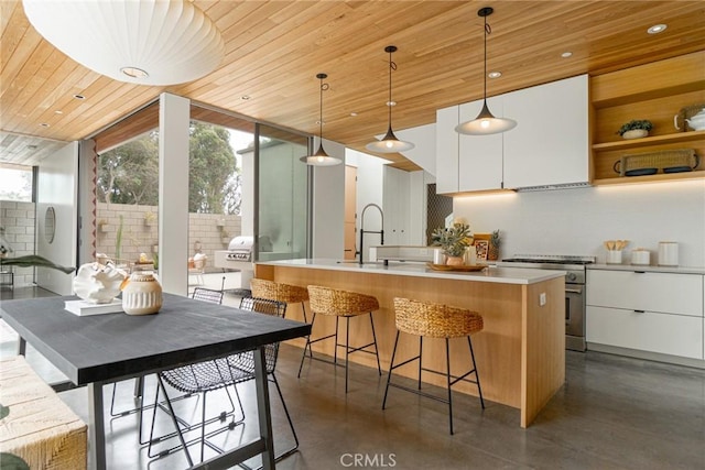 1357 Voorhees Ave, Manhattan Beach, CA 90266 - kitchen with high end range, wooden ceiling, white cabinets, modern cabinets, and tasteful backsplash