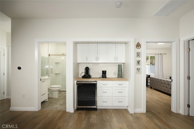 11101 Sarah St, Toluca Lake, CA 91602 - indoor bar with beverage cooler, dark wood-type flooring, and baseboards