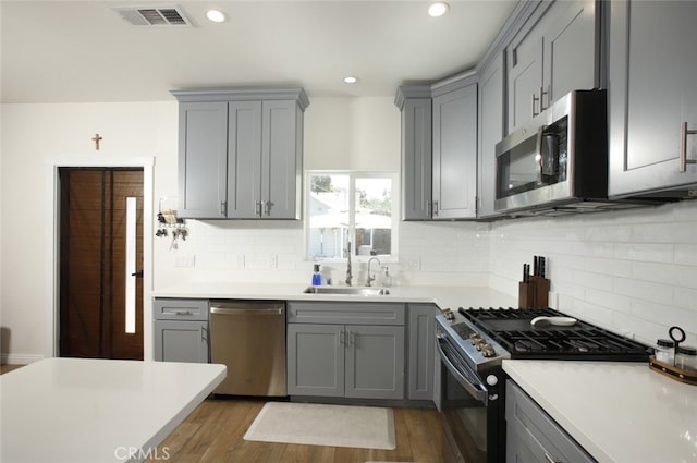 11101 Sarah St, Toluca Lake, CA 91602 - kitchen with appliances with stainless steel finishes, gray cabinets, a sink, backsplash, and recessed lighting