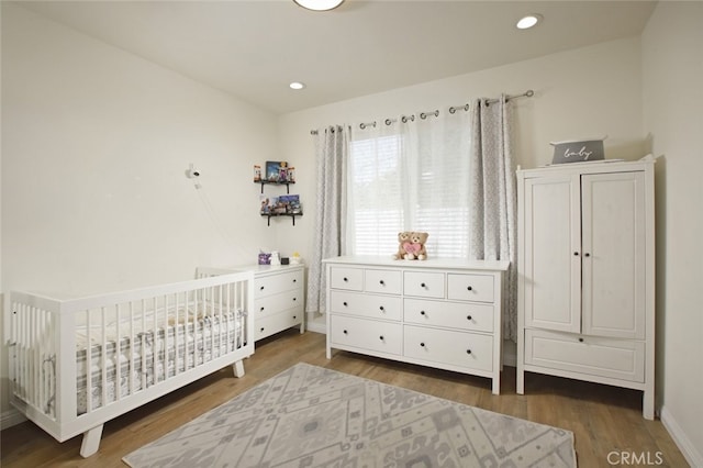 11101 Sarah St, Toluca Lake, CA 91602 - bedroom with wood finished floors, baseboards, a crib, and recessed lighting