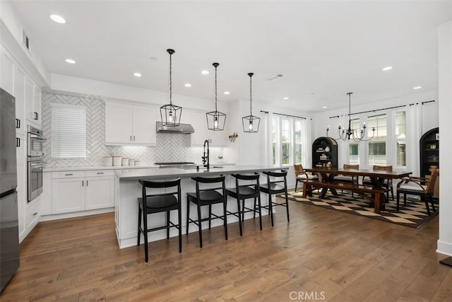 24 Vasto St, Rancho Mission Viejo, CA 92694 - kitchen featuring tasteful backsplash, white cabinetry, a breakfast bar, a kitchen island with sink, and recessed lighting