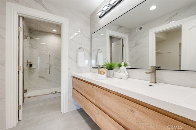 7655 Caminito Avola Ln, Jolla, CA 92037 - full bath with a marble finish shower, double vanity, tile walls, tile patterned floors, and recessed lighting