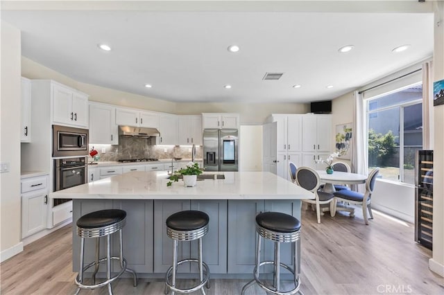 18680 Vantage Pointe Dr, Rowland Heights, CA 91748 - kitchen featuring stainless steel appliances, under cabinet range hood, light wood-type flooring, a sink, and white cabinetry