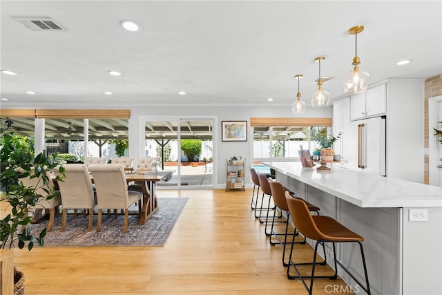 12921 Eveningside Dr, North Tustin, CA 92705 - kitchen with high quality fridge, white cabinets, crown molding, light wood finished floors, and recessed lighting