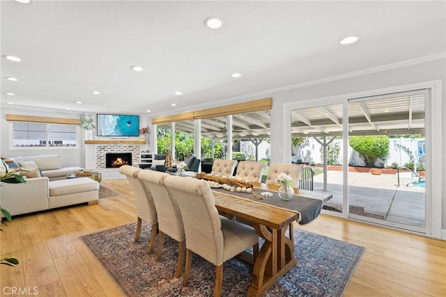 12921 Eveningside Dr, North Tustin, CA 92705 - dining area with crown molding, plenty of natural light, a lit fireplace, light wood-type flooring, and recessed lighting