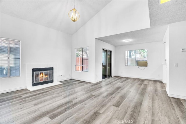 15696 Paine St, Fontana, CA 92336 - unfurnished living room featuring high vaulted ceiling, wood finished floors, a chandelier, a brick fireplace, and baseboards